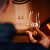 Weyermann® Whisky in einem Whisky Glas im Hintergrund ein Whisky Fass