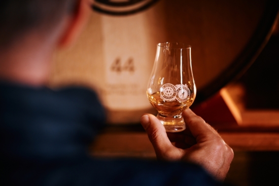 Weyermann® Whisky in einem Whisky Glas im Hintergrund ein Whisky Fass